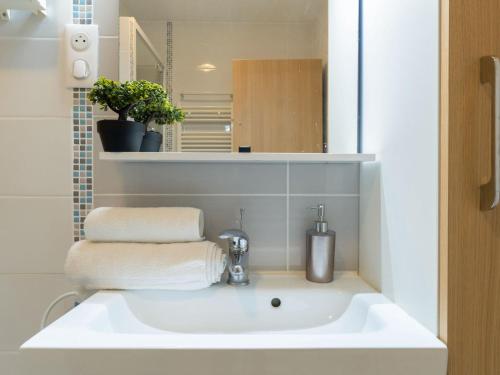 une salle de bain avec un lavabo blanc et un miroir dans l'établissement Apartment Résidence du Port-4 by Interhome, à Arcachon