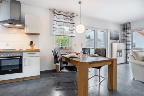 a kitchen and dining room with a wooden table and chairs at Ferienvilla Kapitänshaus in Ostseebad Karlshagen