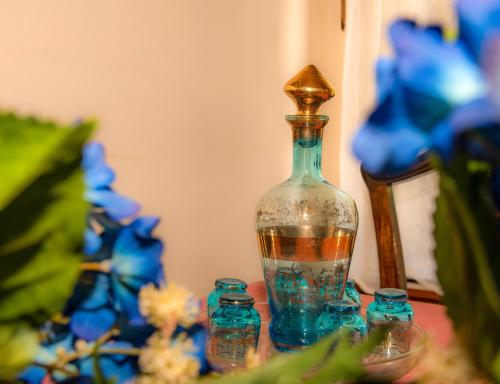 a glass vase sitting on a table with blue flowers at La Casa De Vacation in Lafkos