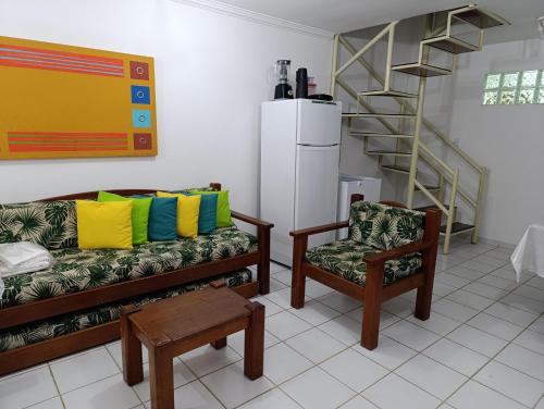 uma sala de estar com um sofá e uma cadeira em Casa Duplex 3 suítes em Condomínio Fechado em Porto Seguro