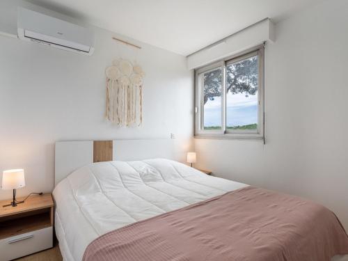 une chambre blanche avec un lit et une fenêtre dans l'établissement Apartment Le Zodiaque II-4 by Interhome, à Hyères