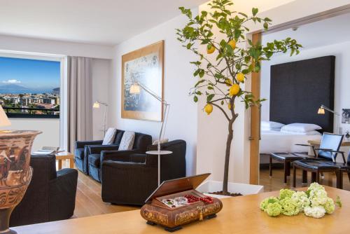 a living room with a table with a tree in it at Hilton Sorrento Palace in Sorrento