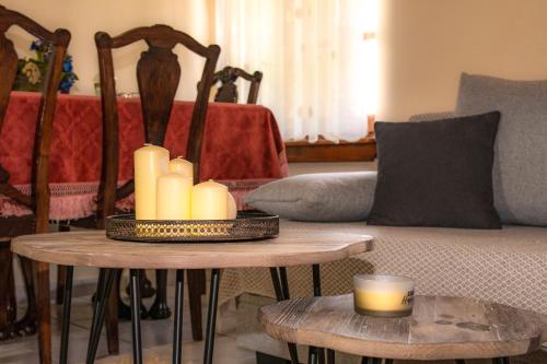 a living room with a couch and two tables with candles at La Casa De Vacation in Lafkos