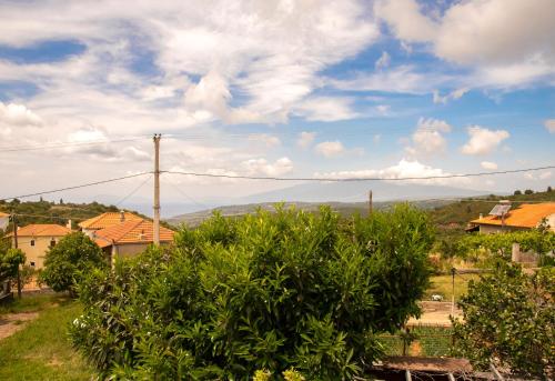 a house with a bush in the foreground at La Casa De Vacation in Lafkos