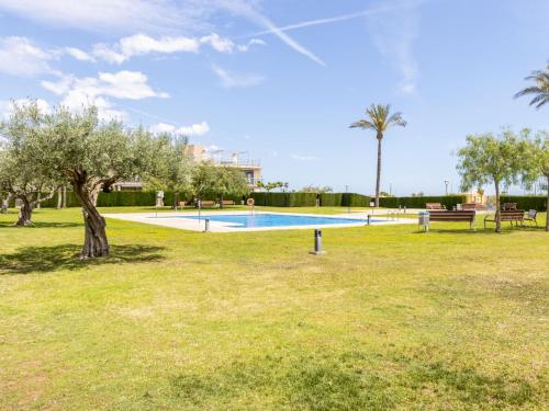 a park with a swimming pool and a tree at Apartment Viena 13 by Interhome in L'Ampolla