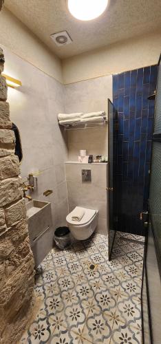 a bathroom with a toilet and a tile floor at וילה תהילה המחודש - The new Villa Tehila in Rosh Pinna