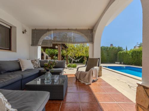 sala de estar con sofá, mesa y piscina en Villa Alicia by Interhome, en L'Ampolla