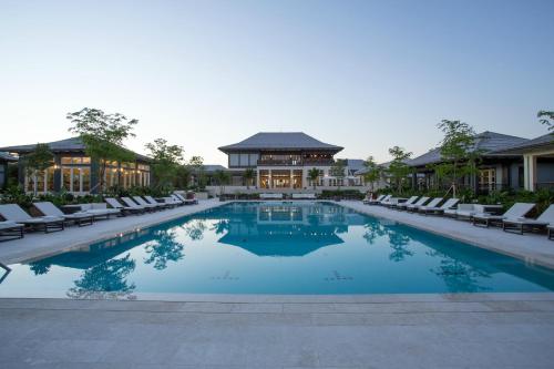 a swimming pool with lounge chairs and a building at The Island House in Nassau
