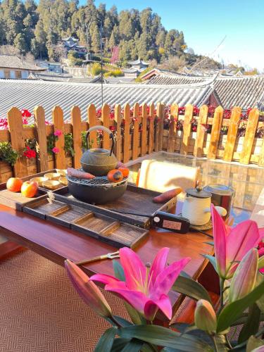 a table with fruits and vegetables on a patio at Lijiang Old Town Meiliju View Inn in Lijiang