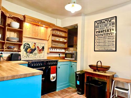 a kitchen with blue cabinets and a stove top oven at Zeta Cottage in Ryde