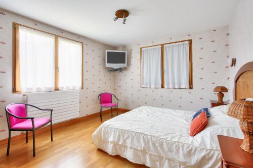 - une chambre avec un lit et deux chaises roses dans l'établissement Maison pour 8 avec jardin avec vue sur le port, à Pléneuf-Val-André