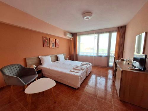 a hotel room with a bed and a chair at Guest House Starata Kushta in Lozenets