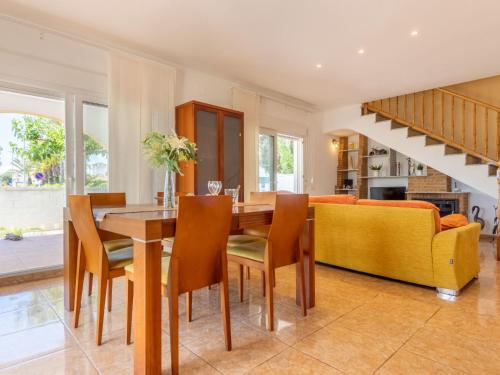 a dining room with a table and chairs and a couch at Holiday Home Dani by Interhome in L'Eucaliptus