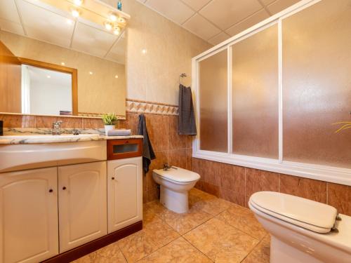 a bathroom with a toilet and a sink and a mirror at Holiday Home Dani by Interhome in L'Eucaliptus
