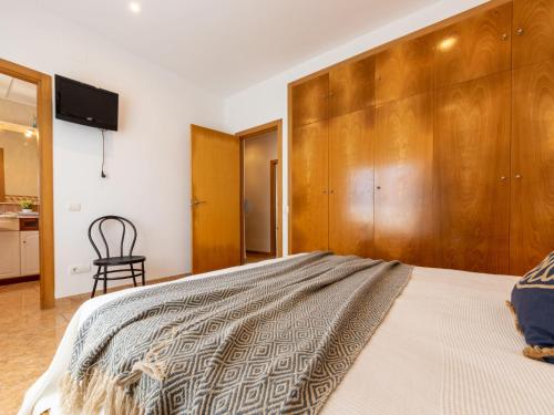 a bedroom with a large bed with a wooden wall at Holiday Home Dani by Interhome in L'Eucaliptus