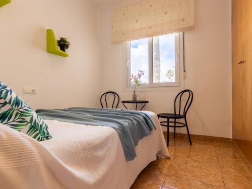 a bedroom with a bed and a window and a table at Holiday Home Dani by Interhome in L'Eucaliptus