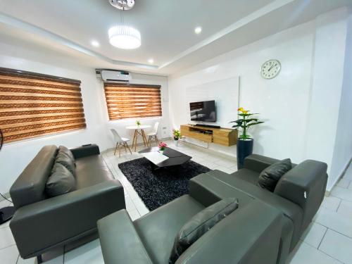 a living room with a couch and a tv at Topaz Pearl Exquisite Apartments in Lekki