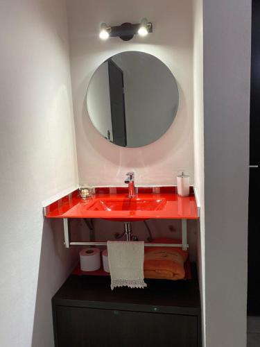 a bathroom with a red sink and a mirror at Descanso de Liniers in Alta Gracia