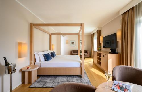 a hotel room with a bed and a tv at Leonardo Hotel Lago di Garda - Wellness and Spa in Lazise