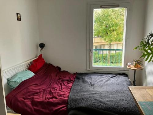 un lit assis dans une pièce avec une fenêtre dans l'établissement Maison de ville 102m2 3 chambres, à Montigny-le-Bretonneux