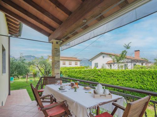 a table on a balcony with a view of a house at Holiday Home Casa Albertosa by Interhome in Marina di Massa