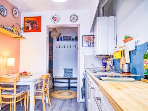 une cuisine avec des armoires blanches et une table et des chaises dans l'établissement Apartment Chez Lucie by Interhome, à Aix-en-Provence