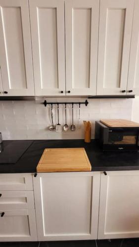 - un comptoir de cuisine avec des placards blancs et un four micro-ondes dans l'établissement Fully Renovated Historic Apt in Heart Mouffetard, à Paris