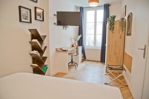 une chambre avec un lit, un bureau et une fenêtre dans l'établissement Fully Renovated Historic Apt in Heart Mouffetard, à Paris