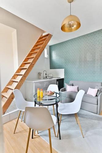 un salon avec une table, des chaises et un canapé dans l'établissement Appartement avec Mezzanine au centre de Paris - II, à Paris