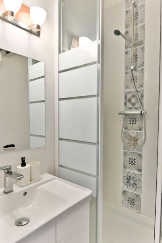 une salle de bain blanche avec un lavabo et une douche dans l'établissement Appartement avec Mezzanine au centre de Paris - II, à Paris