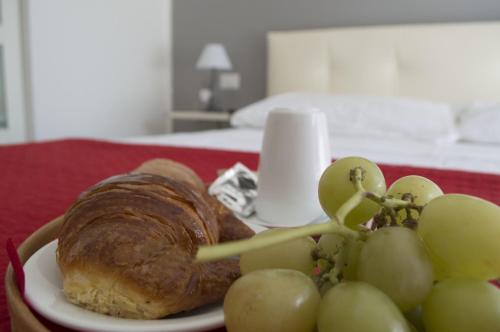 een bord met eten, een croissant en druiven bij Domus Raffaello in Rome