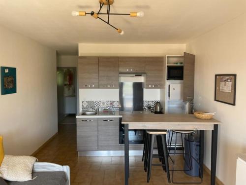 une cuisine avec un grand îlot et des tabourets de bar dans l'établissement Apartment Les myrtilles-1 by Interhome, à Six-Fours-les-Plages