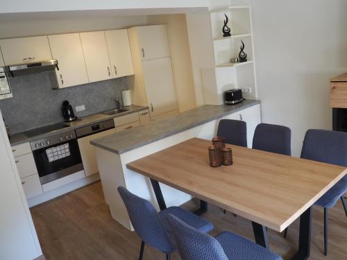 a kitchen with a wooden table and blue chairs at Ferienwohnung Wiesheim in Bad Hofgastein