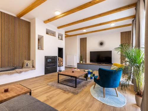 a living room with a blue chair and a couch at Holiday Home Vuk by Interhome in Kupjak