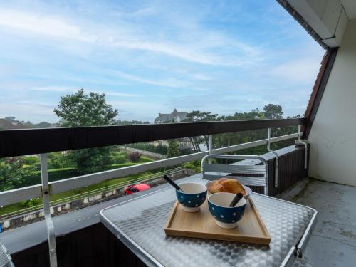 un plateau avec deux bols de nourriture sur une table sur un balcon dans l'établissement Studio Les flots bleu by Interhome, à Trouville-sur-Mer