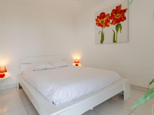 - un lit blanc dans une chambre blanche avec deux lampes dans l'établissement Studio Les flots bleu by Interhome, à Trouville-sur-Mer