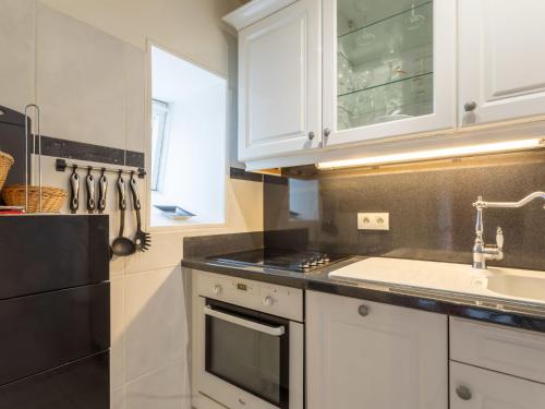 une cuisine avec des armoires blanches et un évier dans l'établissement Studio Les flots bleu by Interhome, à Trouville-sur-Mer