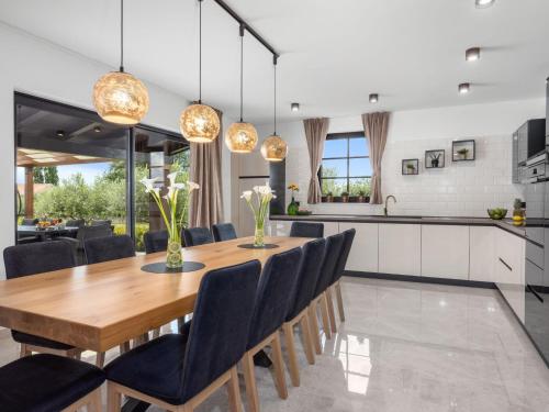 a kitchen and dining room with a wooden table and chairs at Holiday Home Villa Venezia by Interhome in Labin