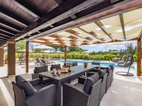 a patio with a table and chairs and a pool at Holiday Home Villa Venezia by Interhome in Labin