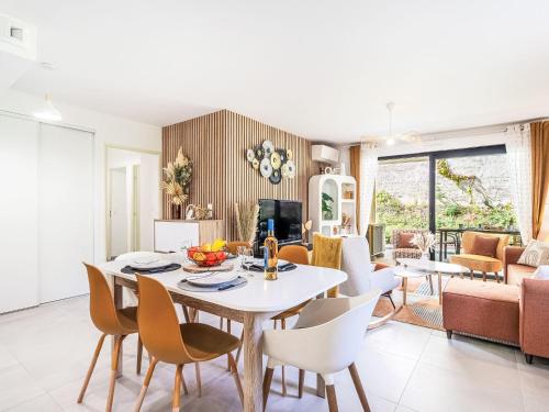 une salle à manger et un salon avec une table et des chaises dans l'établissement Apartment Le Clos des Restanques by Interhome, à Cogolin