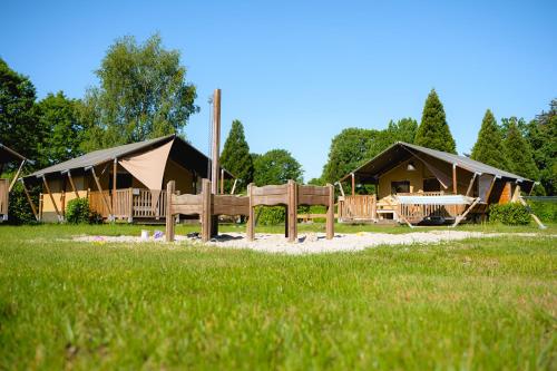 a group of tents in a field with grass at Glamping de Schatberg in Sevenum