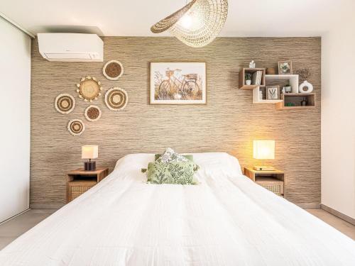 une chambre avec un grand lit blanc avec deux tables dans l'établissement Apartment Le Clos des Restanques by Interhome, à Cogolin