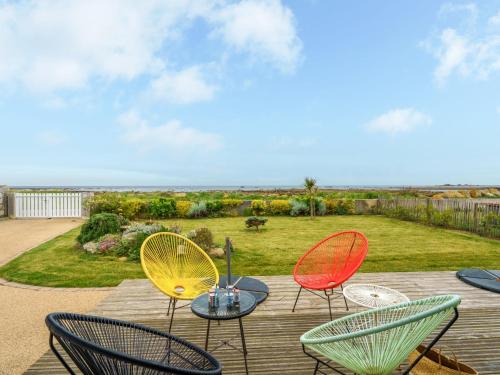 un groupe de chaises et une table sur une terrasse dans l'établissement Holiday Home Les pieds dans l'eau by Interhome, à Penmarcʼh