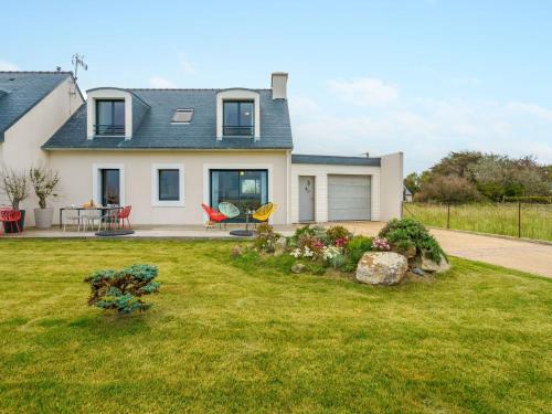 une maison avec une cour avec de l'herbe verte dans l'établissement Holiday Home Les pieds dans l'eau by Interhome, à Penmarcʼh