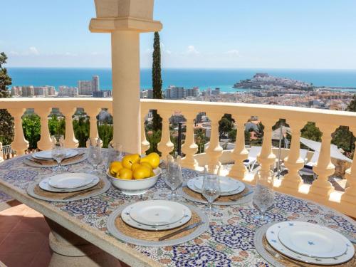 a table with plates and bowls of fruit on a balcony at Holiday Home Villa Bellevue by Interhome in Peñíscola