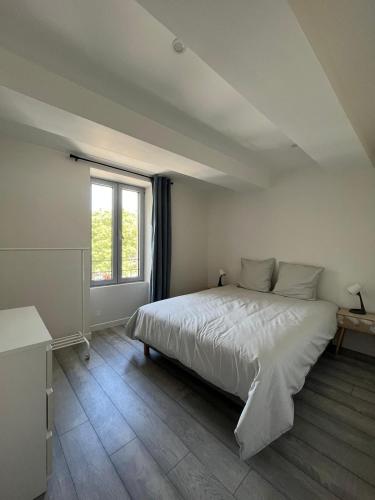 une chambre avec un grand lit blanc et une fenêtre dans l'établissement Orange Allure Flats, à Orange