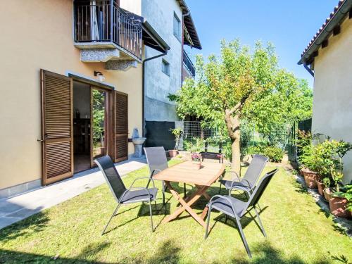 patio con mesa de madera y sillas en Holiday Home Sky & Lake by Interhome, en Arizzano