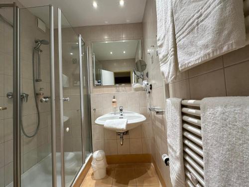 a bathroom with a shower and a sink and a shower at Köhlers Forsthaus Wellness & Genuss Hotel in Aurich