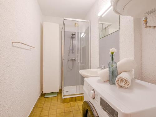 une salle de bain blanche avec un lavabo et une douche dans l'établissement Apartment Lou Gabian-2 by Interhome, à Saint-Aygulf