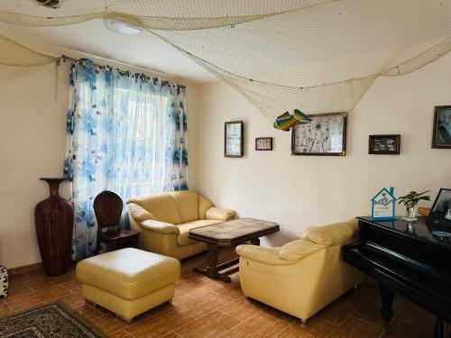 a living room with two chairs and a piano at Claude Monet beach hotel in Ureki